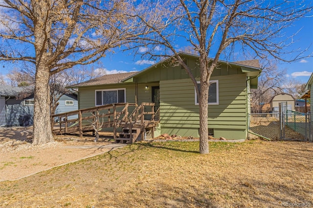 view of front of home with fence, a front lawn, and a wooden deck