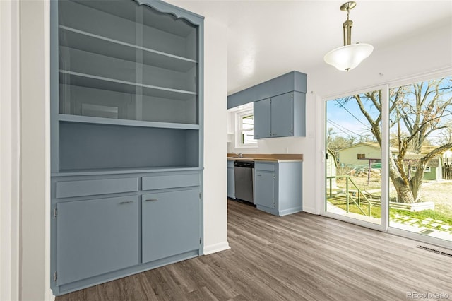 interior space with dark wood-type flooring, visible vents, stainless steel dishwasher, open shelves, and decorative light fixtures