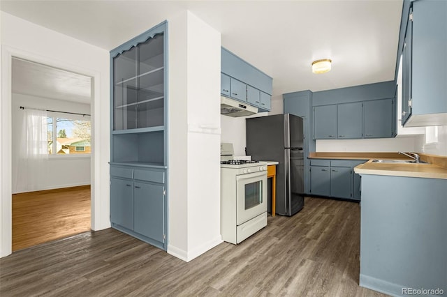 kitchen featuring blue cabinets, under cabinet range hood, dark wood-type flooring, and gas range gas stove