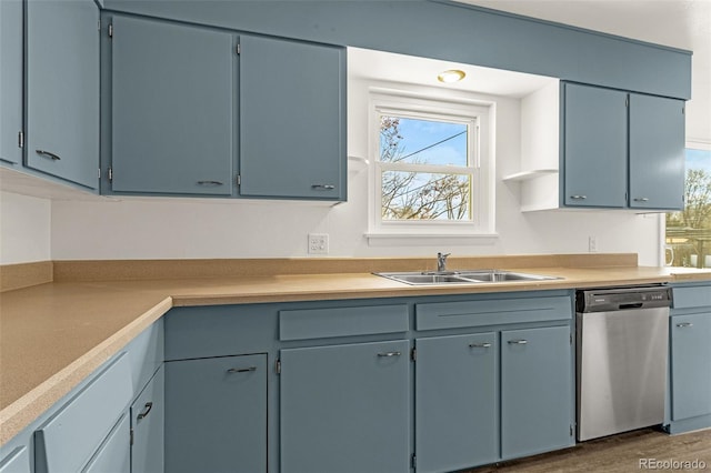 kitchen with dishwasher, light countertops, a sink, and dark wood-style floors