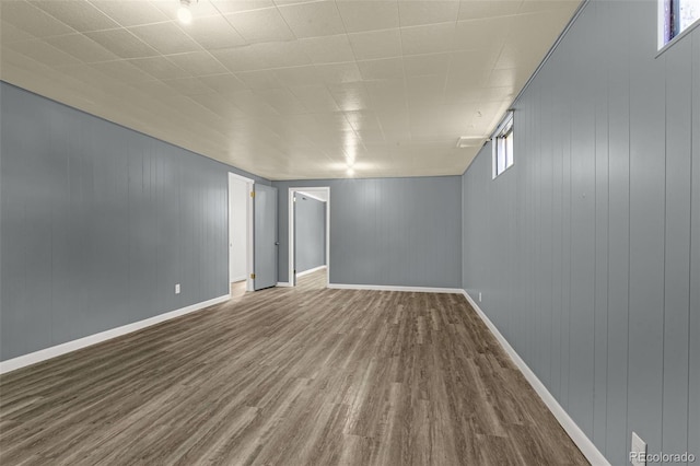 unfurnished room featuring a healthy amount of sunlight, wood finished floors, and baseboards