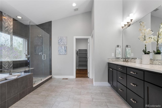 full bathroom featuring baseboards, visible vents, a shower stall, vanity, and a walk in closet