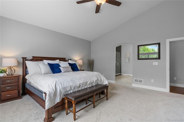 bedroom featuring visible vents, baseboards, ceiling fan, arched walkways, and light colored carpet