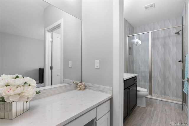 full bathroom with a shower stall, visible vents, toilet, and vanity
