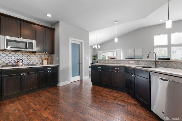 kitchen featuring vaulted ceiling, backsplash, stainless steel appliances, and a sink