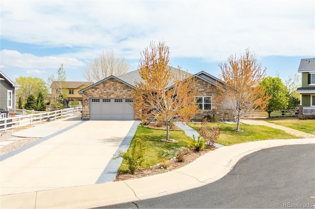 view of front facade with fence, stone siding, concrete driveway, a garage, and a front yard