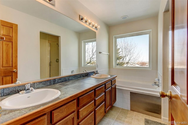 full bathroom featuring double vanity, a garden tub, a sink, and tile patterned floors