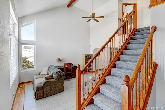 stairs featuring beam ceiling, high vaulted ceiling, and a wealth of natural light