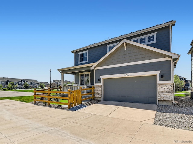 11902 Norfolk Ct, Commerce City, CO 80022 - view of front of home with driveway, a porch, stone siding, a garage, and a residential view