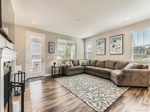 11902 Norfolk Ct, Commerce City, CO 80022 - living room featuring wood finished floors, a stone fireplace, and recessed lighting