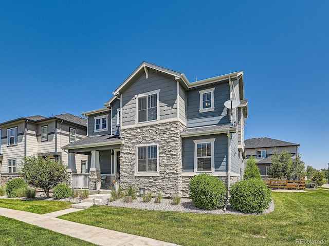 11902 Norfolk Ct, Commerce City, CO 80022 - view of front of house with stone siding, a front lawn, and covered porch