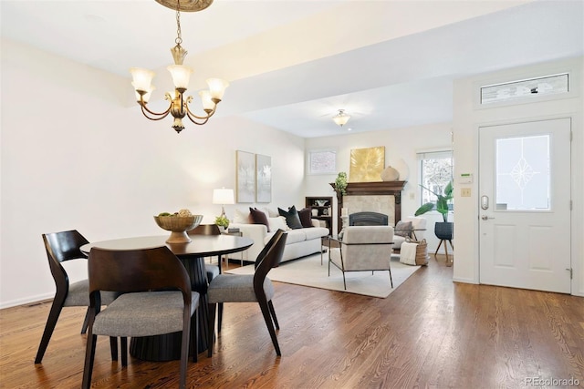443 Garfield St, Denver, CO 80206 - dining space with a chandelier, wood finished floors, a tile fireplace, and baseboards