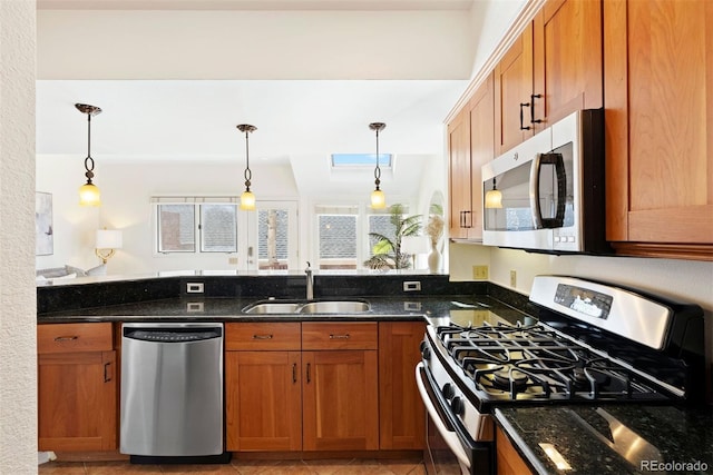 443 Garfield St, Denver, CO 80206 - kitchen featuring stainless steel appliances, a sink, brown cabinetry, and dark stone counters