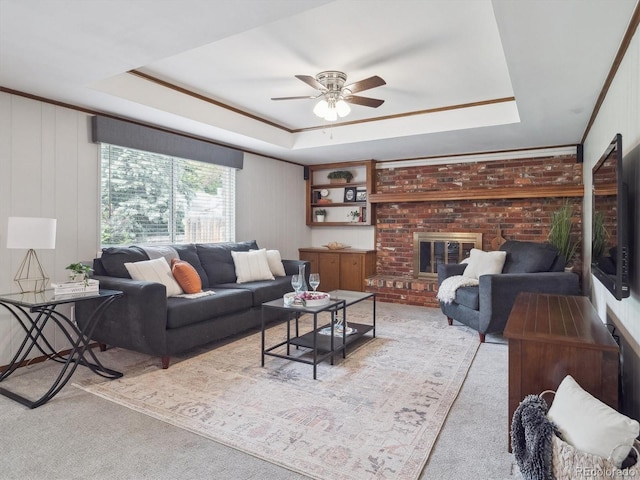 6898 W Nova Dr, Littleton, CO 80128 - living room featuring a raised ceiling, a ceiling fan, carpet floors, a fireplace, and crown molding