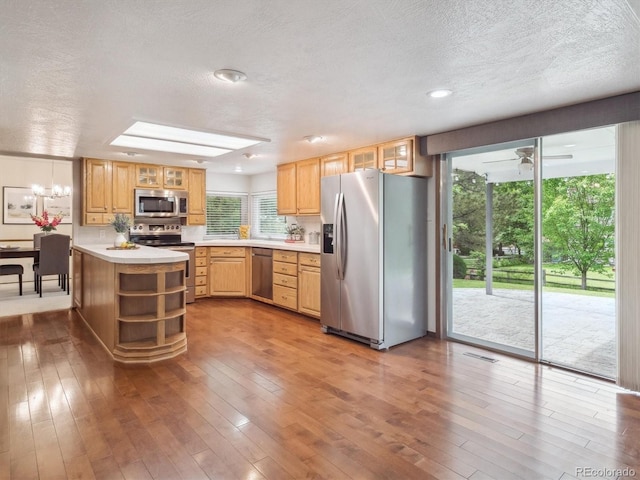 6898 W Nova Dr, Littleton, CO 80128 - kitchen with appliances with stainless steel finishes, open shelves, light countertops, wood-type flooring, and a textured ceiling
