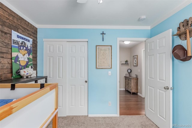 carpeted bedroom featuring ornamental molding, a closet, and baseboards