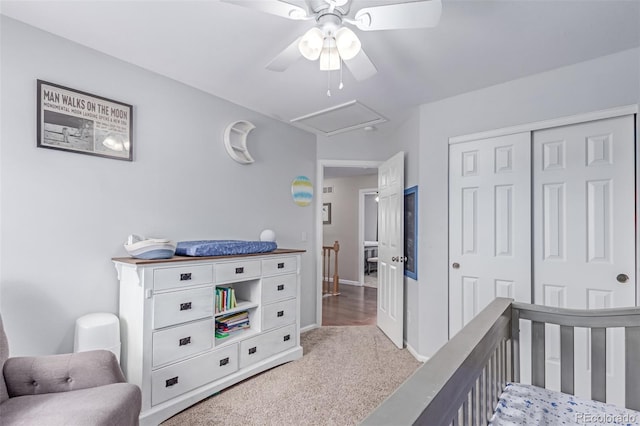 bedroom featuring light carpet, a closet, a ceiling fan, a nursery area, and baseboards