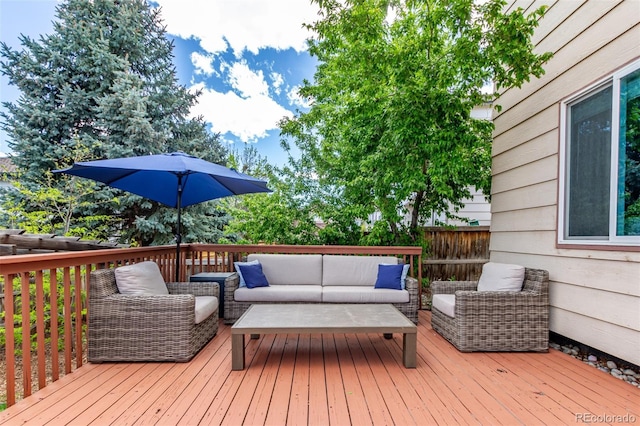 wooden terrace with outdoor lounge area and fence