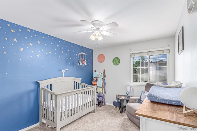 carpeted bedroom featuring an accent wall, a ceiling fan, baseboards, and wallpapered walls