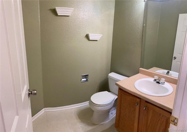 bathroom featuring tile patterned flooring, baseboards, toilet, and vanity