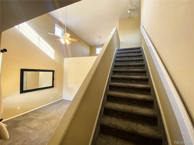 stairway featuring carpet flooring, high vaulted ceiling, baseboards, and ceiling fan