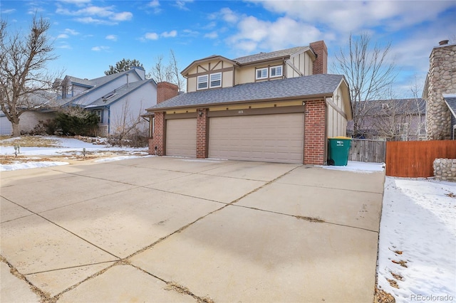 view of front of property featuring a garage, brick siding, fence, and driveway