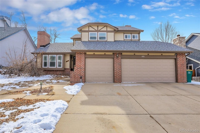 view of front of property featuring driveway, brick siding, and a chimney