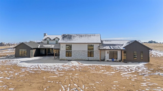 view of snow covered back of property