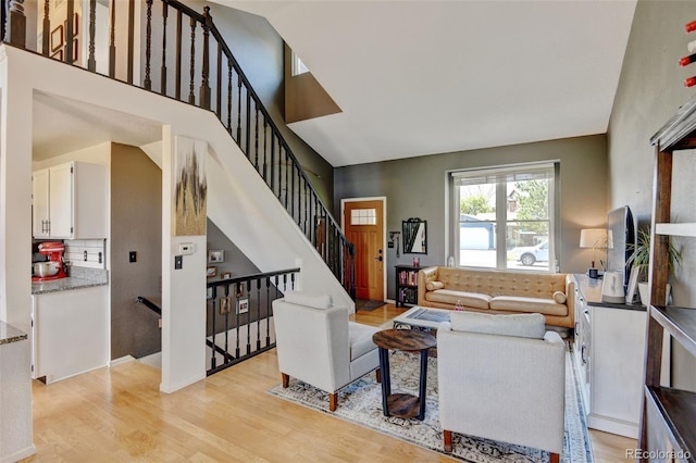 8680 Apache Plume Dr, Parker, CO 80134 - living area with light wood finished floors, a towering ceiling, and stairway
