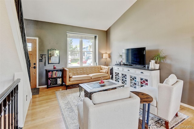 8680 Apache Plume Dr, Parker, CO 80134 - living area featuring light wood finished floors, lofted ceiling, and baseboards