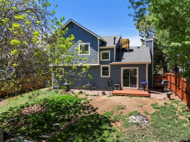 8680 Apache Plume Dr, Parker, CO 80134 - back of house featuring a fenced backyard, a wooden deck, a chimney, and a shingled roof