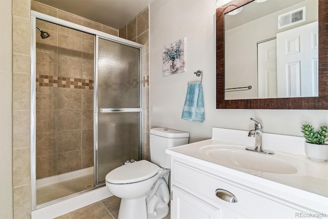 bathroom featuring vanity, a shower with shower door, tile patterned floors, and toilet