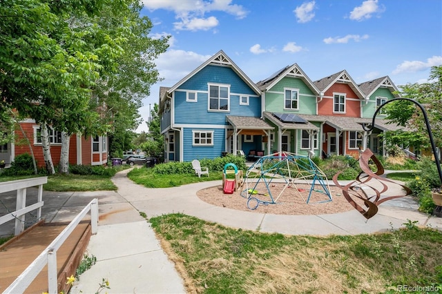 view of front of home with solar panels and a playground