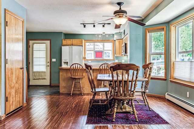 dining area featuring a textured ceiling, ceiling fan, dark hardwood / wood-style floors, and a baseboard heating unit