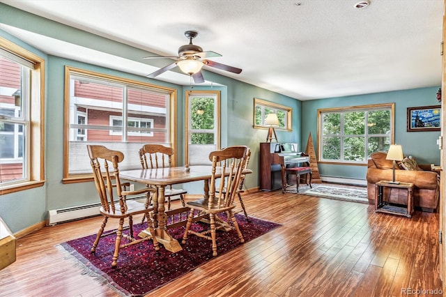 dining area with baseboard heating, ceiling fan, a textured ceiling, and light wood-type flooring