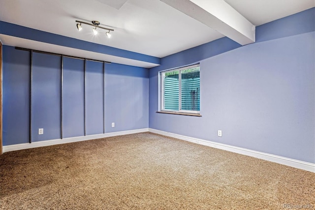 carpeted empty room featuring beamed ceiling