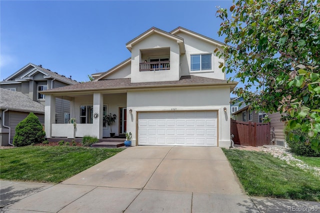 5757 W Alamo Dr, Denver, CO 80123 - traditional-style house with stucco siding, a balcony, a garage, and driveway