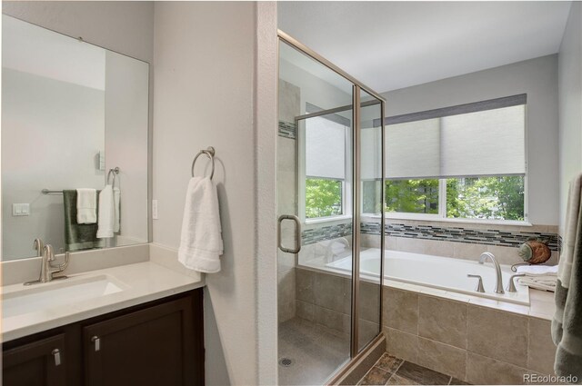 5757 W Alamo Dr, Denver, CO 80123 - full bathroom featuring vanity, a garden tub, and a stall shower