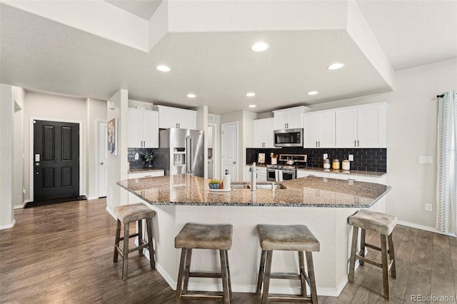 9869 Meridian Hills Trl, Peyton, CO 80831 - kitchen with stainless steel appliances, a kitchen bar, backsplash, dark wood-style flooring, and recessed lighting