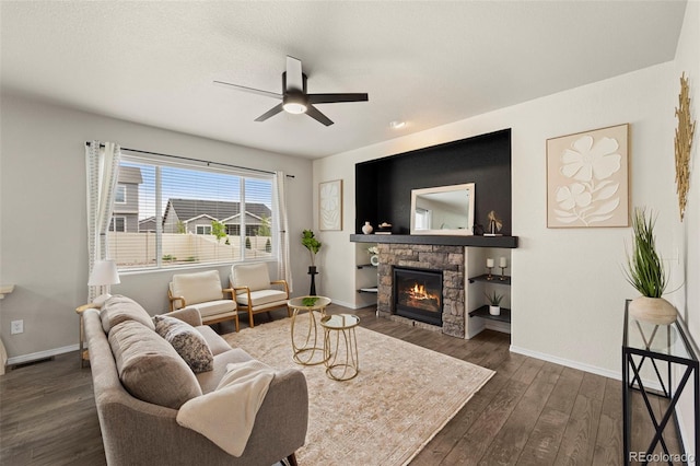 9869 Meridian Hills Trl, Peyton, CO 80831 - living area featuring ceiling fan, dark wood-style floors, and a stone fireplace