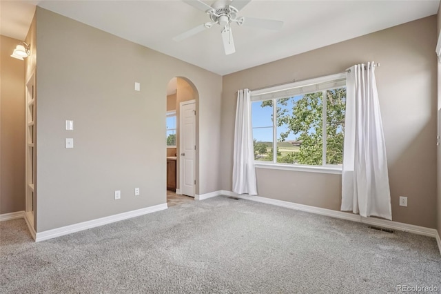 12921 Grant Cir Unit B, Thornton, CO 80241 - empty room with arched walkways, light colored carpet, ceiling fan, and baseboards