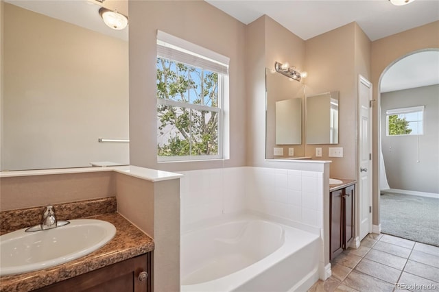 12921 Grant Cir Unit B, Thornton, CO 80241 - bathroom featuring vanity, a garden tub, healthy amount of natural light, and tile patterned flooring