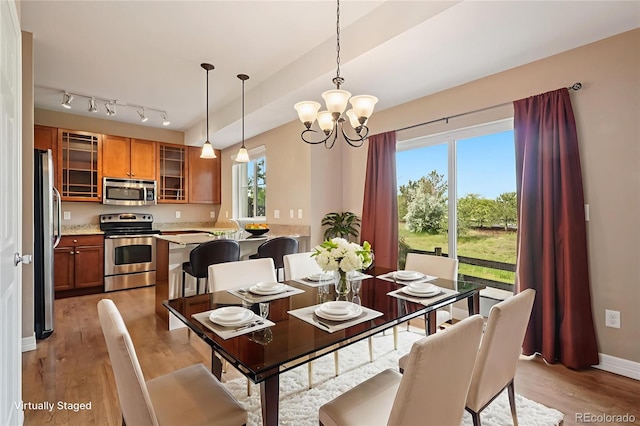 12921 Grant Cir Unit B, Thornton, CO 80241 - dining area with light wood-style flooring and a chandelier