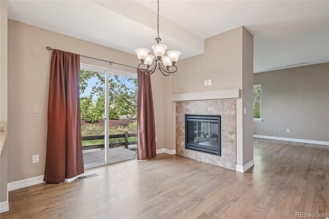 12921 Grant Cir Unit B, Thornton, CO 80241 - unfurnished living room with wood finished floors, healthy amount of natural light, a chandelier, and baseboards