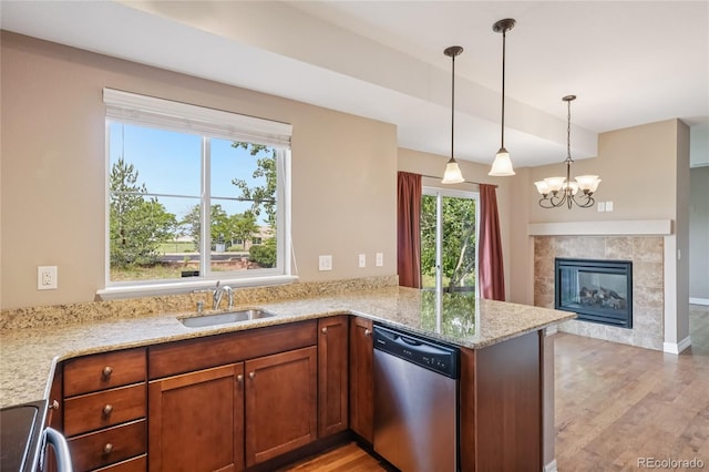 12921 Grant Cir Unit B, Thornton, CO 80241 - kitchen with dishwasher, a peninsula, light wood-type flooring, light stone countertops, and hanging light fixtures