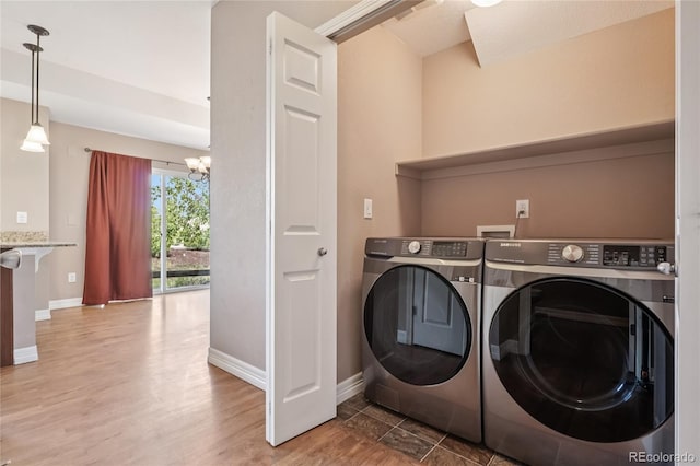 12921 Grant Cir Unit B, Thornton, CO 80241 - laundry room with washing machine and clothes dryer, baseboards, wood finished floors, and a chandelier