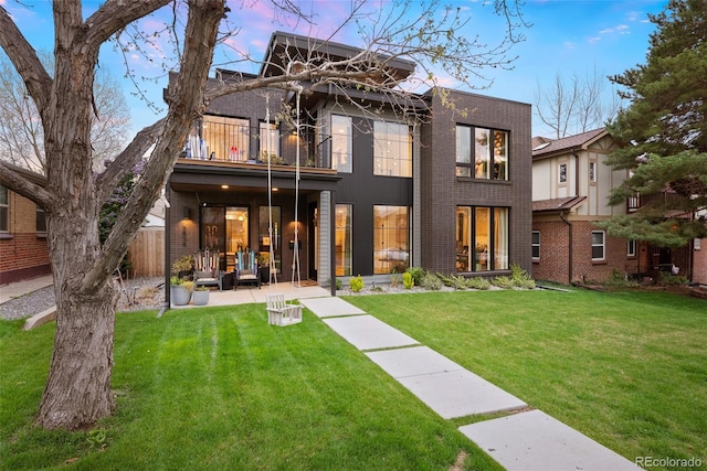 2838 Tennyson St, Denver, CO 80212 - back of house featuring a lawn, fence, brick siding, and a balcony