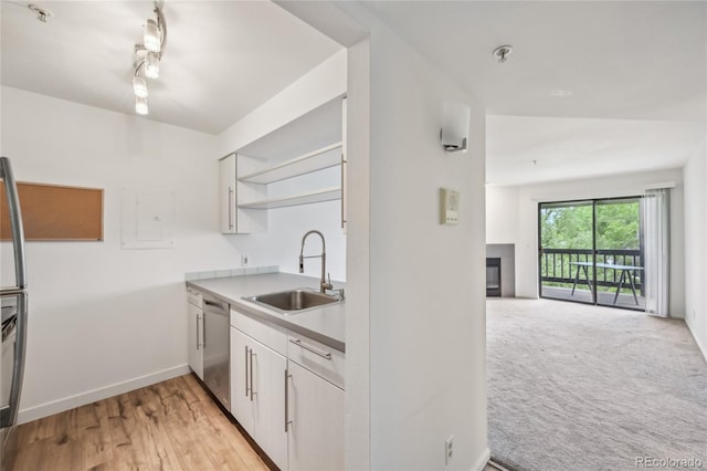 2727 Folsom St Unit 303, Boulder, CO 80304 - kitchen featuring stainless steel dishwasher, a sink, open shelves, a glass covered fireplace, and open floor plan