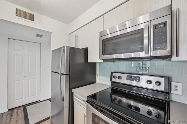 2727 Folsom St Unit 303, Boulder, CO 80304 - kitchen with stainless steel appliances, light countertops, light wood-style flooring, and backsplash