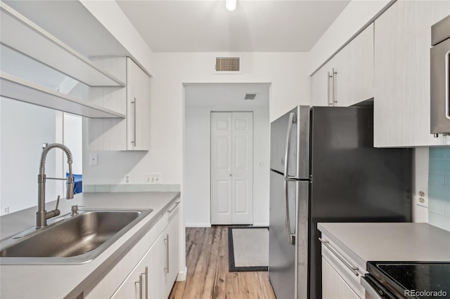 2727 Folsom St Unit 303, Boulder, CO 80304 - kitchen featuring a sink, light wood-type flooring, light countertops, white cabinets, and stainless steel electric range oven